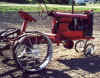 A life size red tractor made from pieces of scrap materials.